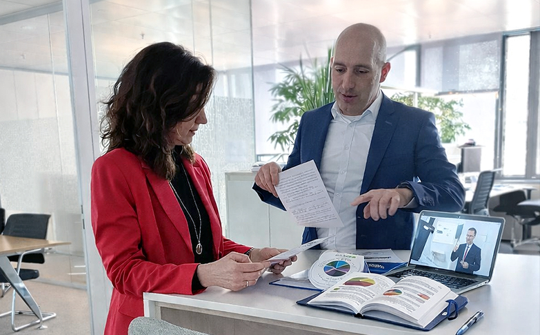 Zwei Geschäftspersonen besprechen Dokumente und Marktanalysen in einer modernen Büroumgebung im Kontext von Gewerbeimmobilien.