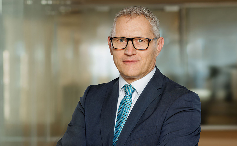 Portrait eines Immobilienberaters im Anzug in moderner Büroumgebung bei fgi Gewerbeimmobilien.