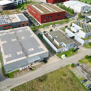 Luftaufnahme eines Gewerbegebiets mit Produktions- und Bürogebäuden zur Darstellung von Immobilien durch Drohnenaufnahmen.