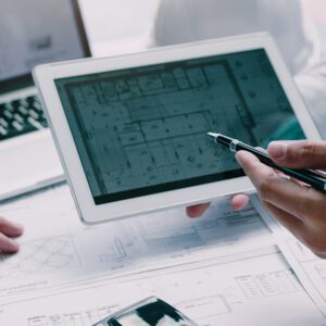 Überarbeitung eines Gebäudegrundrisses auf einem Tablet zur Optimierung der Vermarktung von Gewerbeimmobilien.