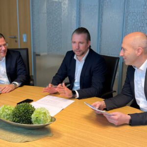 Beratungsgespräch zwischen drei Geschäftspersonen in moderner Büroumgebung zu Gewerbeimmobilien.