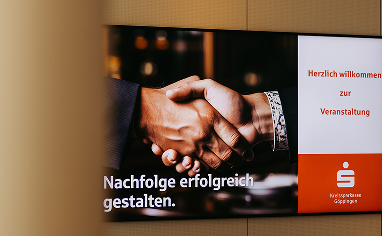 Bildschirm mit dem Veranstaltungsmotto „Nachfolge erfolgreich gestalten“ bei einer Fachveranstaltung der Kreissparkasse Göppingen zur Unternehmensnachfolge.